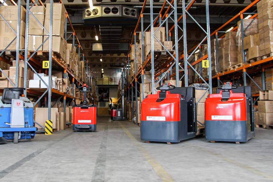 Rode TransClusion magazijntrucks in een fabriekshal, afgeleverd door PTB Transportmiddelen